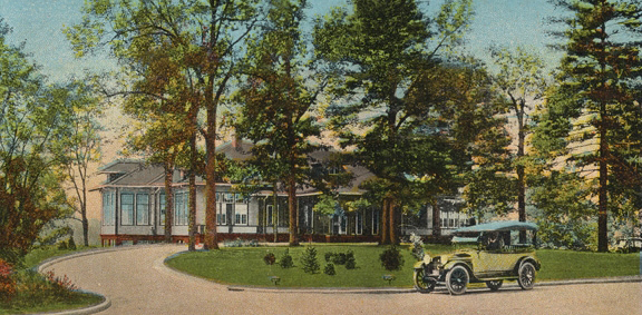 An old photo of a country club with trees and a car in the foreground